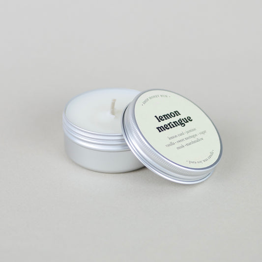 A small sample size lemon meringue scented tin candle with the lid off, showing the candle wick
