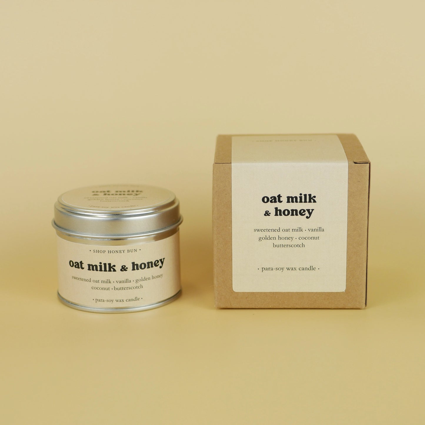 A 20 hour burn time oat milk and honey scented tin candle next to a brown kraft box with a pale yellow paper label