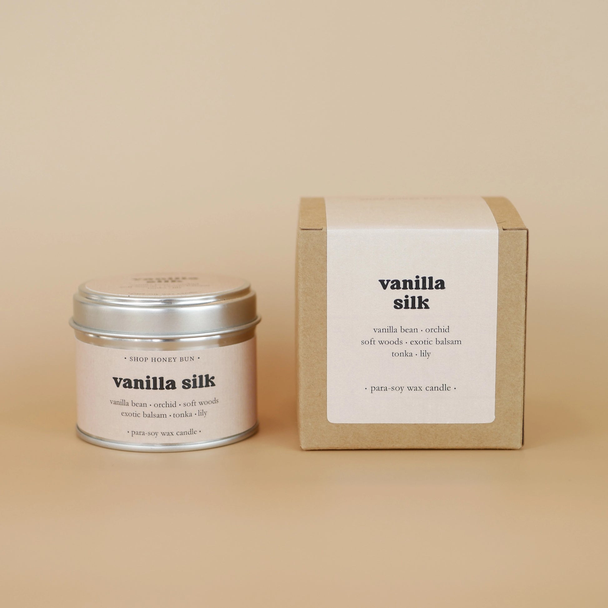 A 20 hour burn time vanilla silk scented tin candle next to a brown kraft box with a beige paper label
