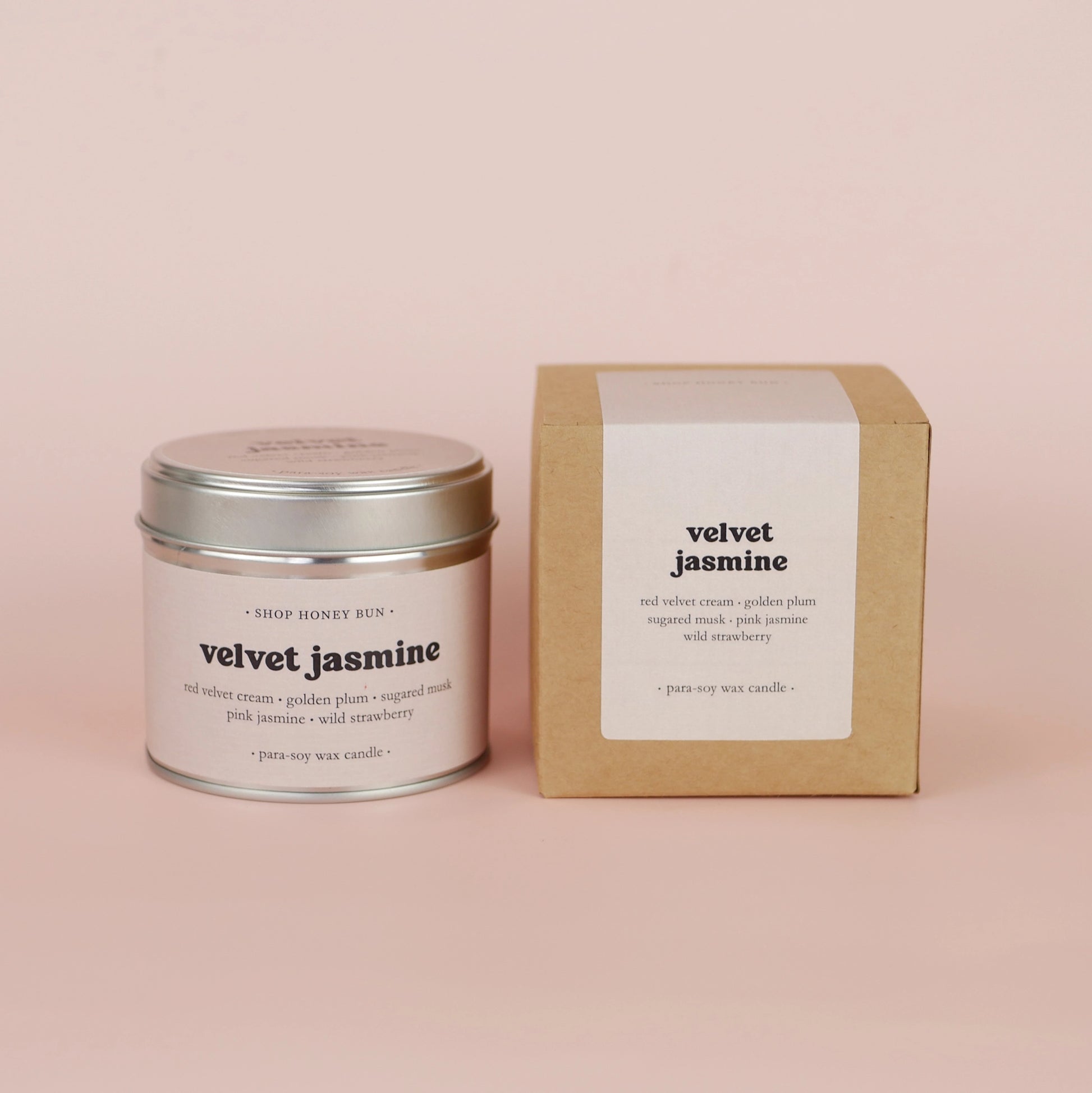 A 30 hour burn time velvet jasmine scented tin candle next to a brown kraft box with a pale pink paper label
